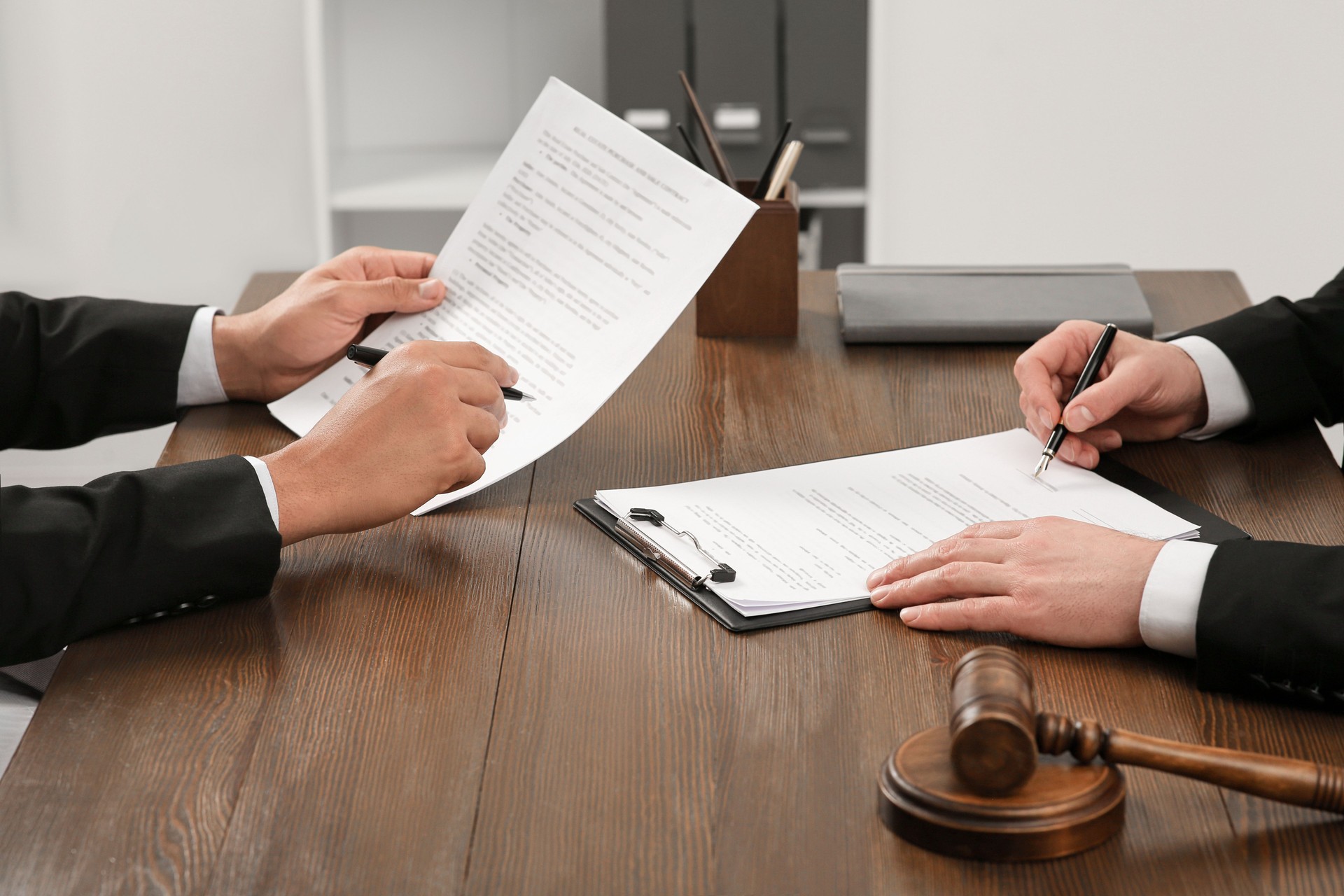 Law and justice. Lawyers working with documents at wooden table in office, closeup